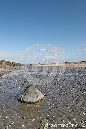 A soothing picture of the wadden sea at paesens moddergat, big rock in foreground, sea and sky Stock Photo