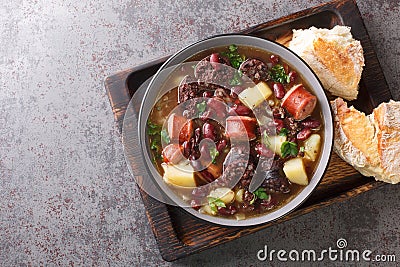 Sopa de pedra Portuguese Stone Soup combination of beans and sausages such as chouriÃ§o and morcilla close up in the plate. Stock Photo