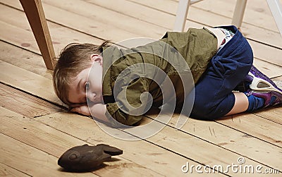 Sorrowful little boy on floor Stock Photo