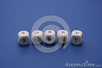 Sorry word on wooden cubes, clasic blue background, copy space. Apology message Stock Photo