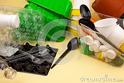 Sorting garbage. Plastic waste for recycling. Plastic bottles, containers, baking soda, forks, spoons, egg packaging, caps. Yellow Stock Photo