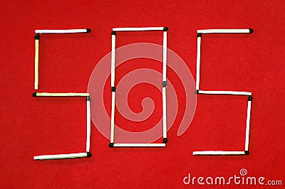 SOS. SOS distress signal icon laid out of matches on a red background. Inscription pine red background. Stock Photo