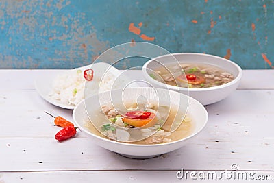 Soto or coto or indonesian beef soup served with white rice, tomato, soy, and green onion Stock Photo