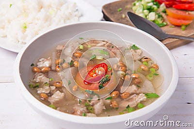 Soto or coto or indonesian beef soup served with white rice, tomato, soy, and green onion Stock Photo