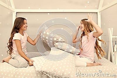 Soulmates girls having fun sleepover party. Girls happy friends with cute pillows. Pillow fight pajama party. Sleepover Stock Photo