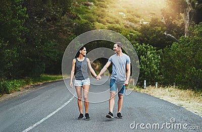 Soulmates share the same sense of direction. a happy young couple walking down a road outside. Stock Photo