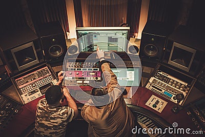 Sound engineer and musician recording song in boutique recording Stock Photo