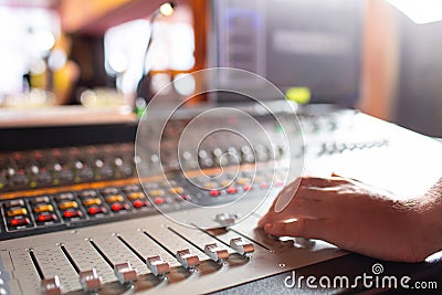 Male hand on control Fader on console. Sound recording studio mixing desk with engineer or music producer Stock Photo