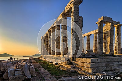 Sounion, Attica / Greece: Colorful sunset at Cape Sounion and the ruins of the temple Poseidon with Patroklos island visible Stock Photo