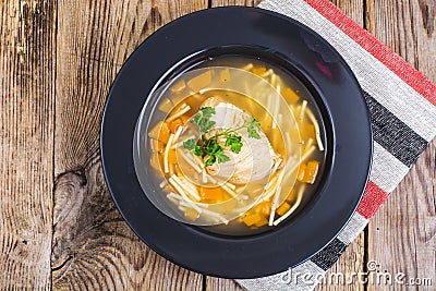 Soup with chicken, pumpkin and noodles on wooden table Stock Photo