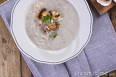 Soup with mushrooms and green onion and cheese. Vintage ceramics. Wooden background. Family home lunch. Free space for text. Stock Photo