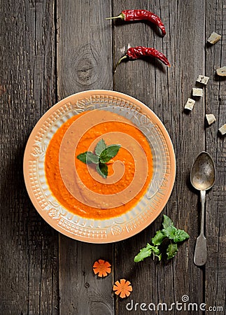 Soup puree of carrots,vintage spoon on a wooden background, top view Stock Photo