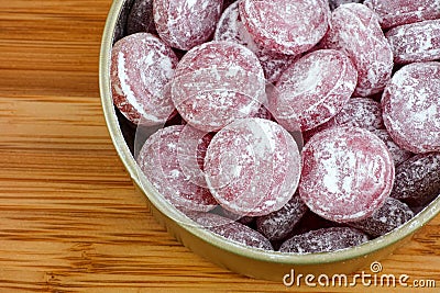 Sour cherry drops. Hard candy with a sour flavor with icing sugar in a tin can Stock Photo