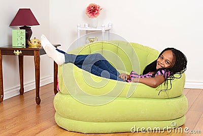 South African child relaxing in green chair Stock Photo