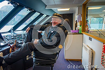 SOUTH ISLAND, NEW ZEALAND- MAY 25, 2017: Close up of a ferry boat pilot command cabin with a smiling captain holding a Editorial Stock Photo