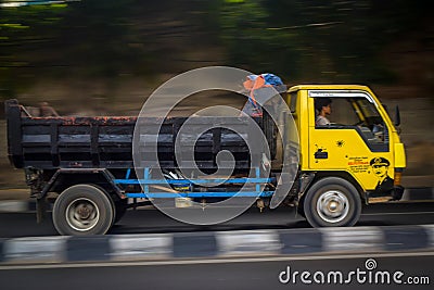 Classic Mitsubishi canter dump truck driving fast on the road blurry in motion Editorial Stock Photo