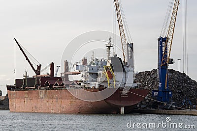 Scrap metal stacked on wharf ready for exporting Editorial Stock Photo