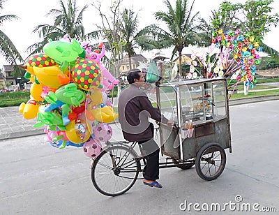 Southeast Asia Vietnam Hoi An Street Hawker on Bicycle Bike motor bike Porter Goods Circus Toys Balloons Fun Joyful Freeride Rider Editorial Stock Photo