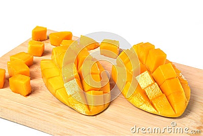 Fresh hedgehog style Mango preparation, cubes and chunks on wooden cutting board, isolated on a white background. Stock Photo