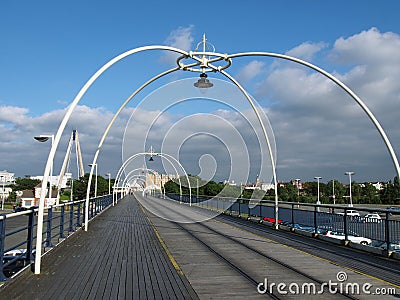 The historic pier in southport merseyside with people walking towards the town and the suspension bridge and buildings visible beh Editorial Stock Photo