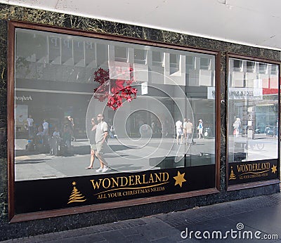 A closed temporary christmas shop in a disused department store on chapel street southport with people walking in past reflected Editorial Stock Photo