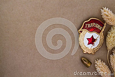 Soviet Bage Â«GuardÂ» and dried flowers and bullet on craft background Stock Photo