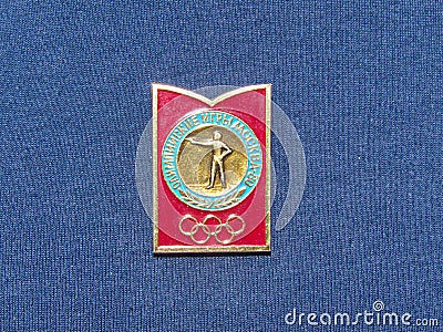 Soviet metal badge featuring the shooters and with the inscription in Russian `Moscow 80, Olympic games` Editorial Stock Photo