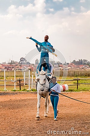 Young African children performing acrobatics on horse back Editorial Stock Photo