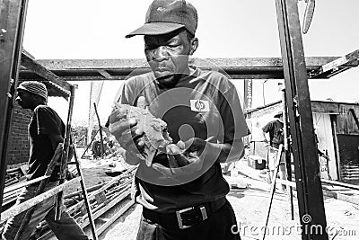 African builder installing windows on a Community Outreach progr Editorial Stock Photo