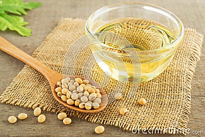 Soy beans and oil on sack Stock Photo