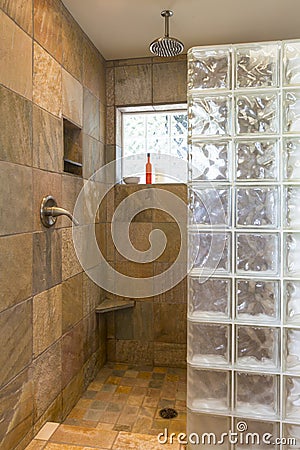 Spa bathroom shower area with stone tile and glass block walls in contemporary upscale home interior Stock Photo