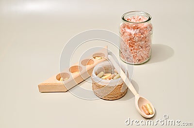 Herb in capsules in wooden bowl on pastel beige background. Beauty products for face and body skin care Stock Photo