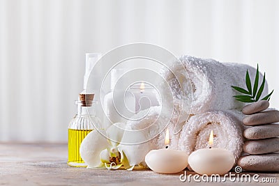 Spa, beauty treatment and wellness background with massage pebbles, orchid flowers, towels, cosmetic products and burning candles Stock Photo