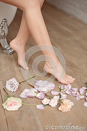 Spa, beauty and wellness bathroom concept with fresh rose petals and flowers scattered around burning candles and the Stock Photo