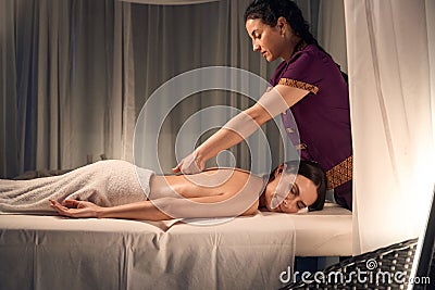 Spa client napping during chiropractic adjustment of her thoracic spine Stock Photo