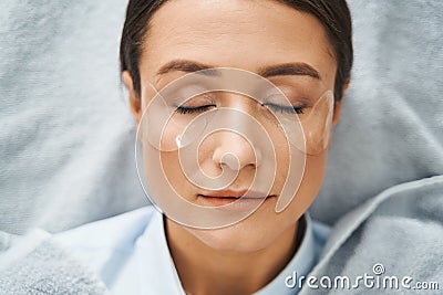 Spa client with under-eye patches napping during the cosmetic procedure Stock Photo