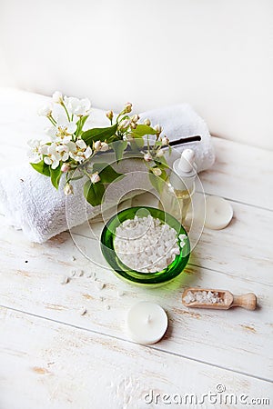 Spa composition with flowers sea salt Massage oil and towel on table Stock Photo