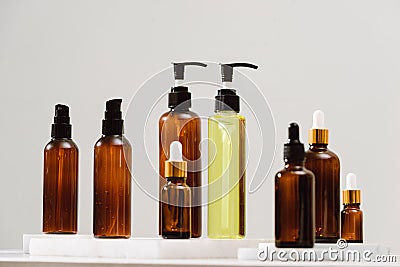 Spa cosmetics in brown glass bottles on gray concrete table. Copy space for text. Beauty blogger, salon therapy, branding mockup, Stock Photo