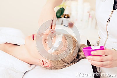 Spa cosmetology. doctor cosmetologist applies cream to face. girl caring for skin. healthy skin concept Stock Photo