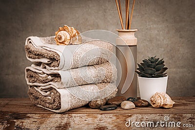 Spa essentials, aroma sticks, stones, towels, sea shell on a wooden rustic background Stock Photo