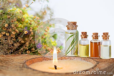 Spa set with burning candle, essential oils in bottles, herbs and flower Stock Photo