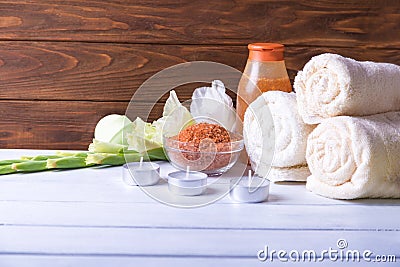 Spa setting with natural olive bath boamb, sea salt, scrub, flowers, towels and candles. On a white wooden table. with copy Stock Photo