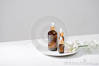 Spa setting with orchids and essential oil in a glass bottle, aromatherapy concept Stock Photo