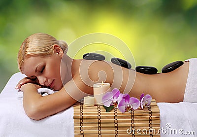 Spa Stone Massage. Blonde Woman Getting Hot Stones Massage Stock Photo