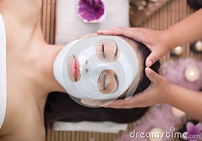 Spa therapy for young woman having facial mask at beauty salon Stock Photo