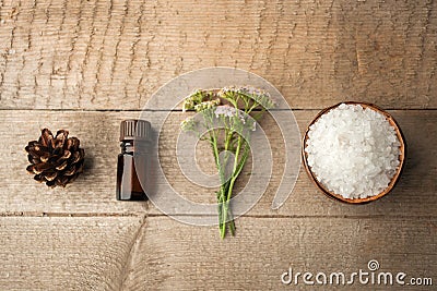 Spa and wellness setting with sea salt, oil essence, cones and candle on wooden background. Fall autumn wellness concept, Relax Stock Photo