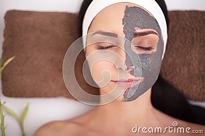 Spa Woman applying Facial cleansing Mask. Beauty Treatments Stock Photo