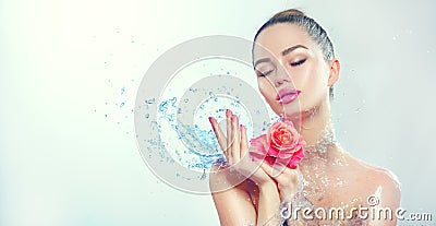 Spa woman. Beauty smiling girl with splashes of water and rose in her hands Stock Photo