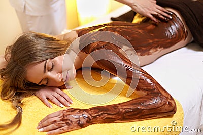 Spa Woman. Young Woman Gets Chocolate Body Mask at Beauty Salon Stock Photo