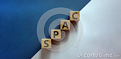 SPAC, special purpose acquisition company symbol. Wooden cubes with word `SPAC` on beautiful white and blue background, copy spa Stock Photo